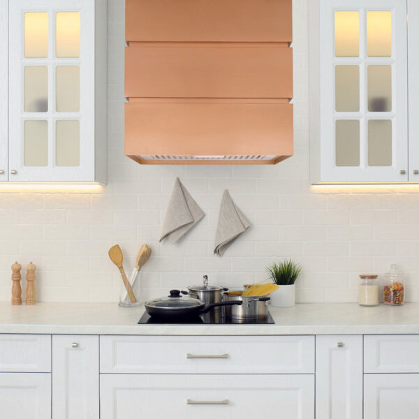 Copper - hued range hood in a bright, modern kitchen