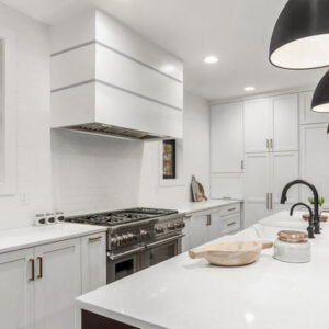 Contemporary stainless - steel range hood in a bright white kitchen