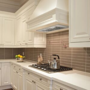 White range hood in a bright, modern kitchen with tiled backsplash