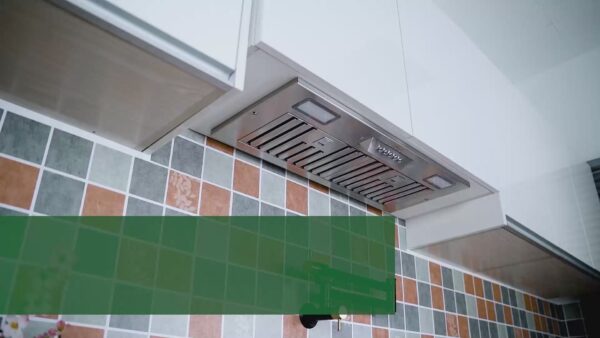 Stainless - steel range hood installed above a colorful tiled backsplash